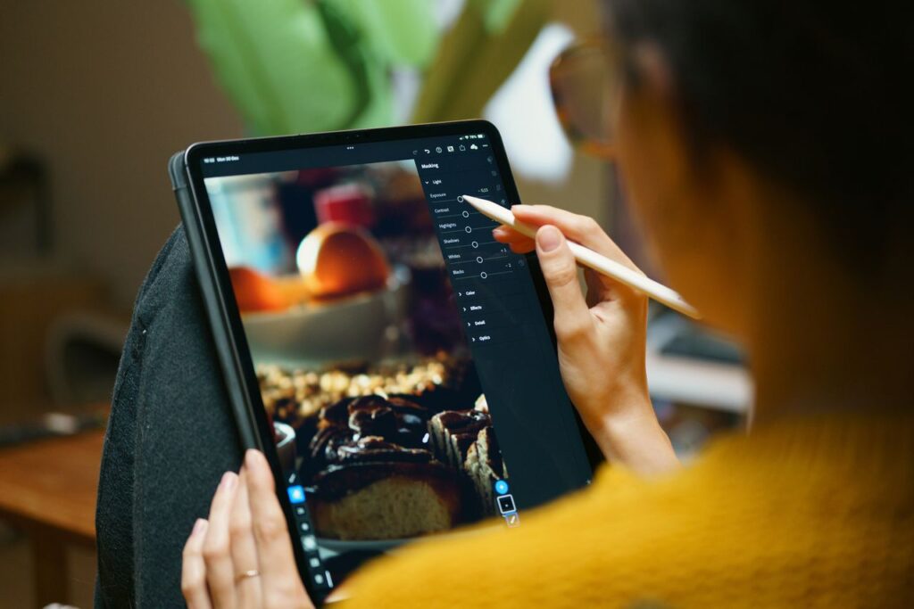 pexels photo 30105086 30105086 A woman uses a stylus to edit photos on a tablet, showcasing freelance creativity.