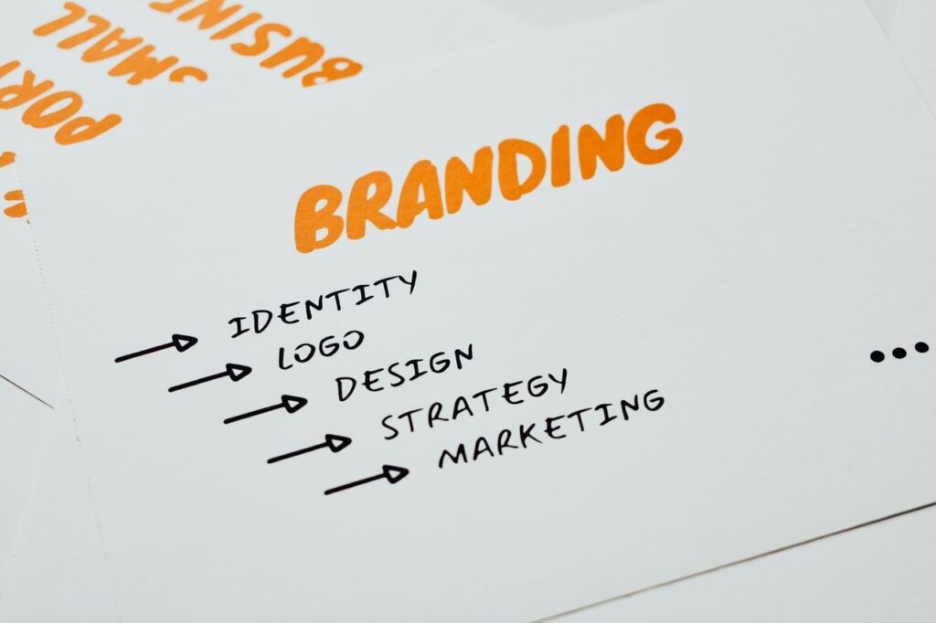 pexels photo 7661184 7661184 Close-up of a paper with branding, identity, design, strategy, and marketing concepts in orange and black.